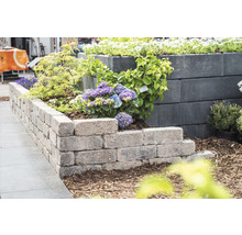 Gestufte Gartenmauer mit Pflanzen für einen strukturierten Außenbereich.