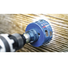 Bohrmaschine mit Bohrkrone bohrt Loch in Holz