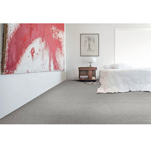 Heller Schlafraum mit grauem Fliesenboden, Bett, Beistelltisch und Kunstwerk