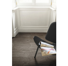 Bodenansicht mit sechseckigen Fliesen in Holzoptik und einem Stuhl mit einer Zeitschrift