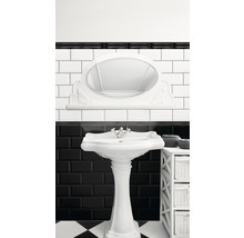 Badezimmer mit Waschtisch und Spiegel im Retro-Stil vor schwarz-weiß gefliester Wand