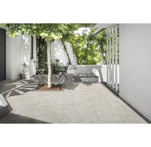 Heller Außenbereich mit Steinboden, Gartenmöbeln und Grünpflanzen