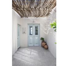 Außenbereich mit grauen Bodenfliesen, heller Wand, zwei Türen und Rohrbdeckung