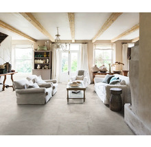 Heller Wohnraum mit Fliesenboden, Sofas und Holzbalken an der Decke