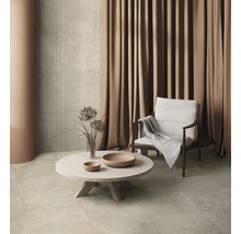 Wohnzimmer mit Sessel, Tisch und Bodenfliesen