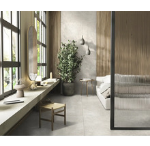 Helles Schlafzimmer mit Bett, Pflanze und Fliesenboden