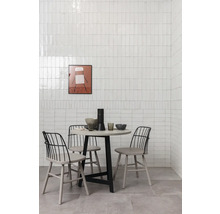 Esszimmer mit rundem Tisch, Stühlen und Wandfliesen