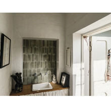 Waschbecken mit Armaturen und Wandfliesen in einem hellen Raum