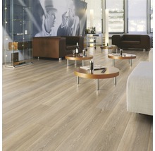 Heller Raum mit Laminatboden in Holzoptik, Sesseln und Tischen.