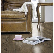 Wohnzimmer mit Laminatboden in Holzoptik, Sessel, Tisch und Buch