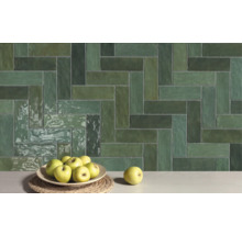 Wandfliesen mit Fischgrätenmuster und Äpfeln auf einem Tisch