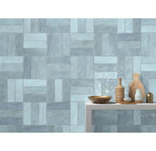 Wandgestaltung mit rechteckigen Fliesen in Fischgrätmuster und Dekoartikeln auf einem Regal