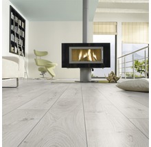 Heller Raum mit Laminatboden, Kaminofen, Sessel und Bücherregal