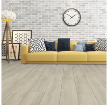 Wohnzimmer mit hellem Holzboden, gelbem Sofa und dekorativen Elementen wie Uhr und Stehlampe