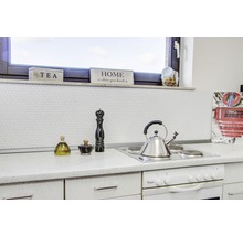 Küchenszene mit Kochfeld, Wasserkocher und Dekorationsgegenständen