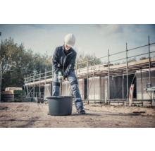 Handwerker mischt Mörtel mit einem Rührwerk auf einer Baustelle.