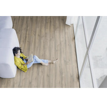 Helle, freundliche Raumszene mit Holzboden und einer Frau, die ein Buch liest