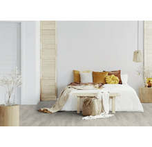 Helles Schlafzimmer mit Bett, Kissen und Holzfußboden