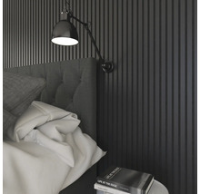 Schlafzimmer mit Wandpaneelen, Bett, Nachttischlampe und Buch