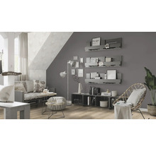 Wohnzimmer mit Sofa, Sessel und Wandregalen unter einer Dachschräge