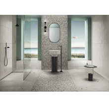 Helles Badezimmer mit Dusche, Waschtisch, Spiegel und Terrazzo Fliesen.