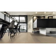 Heller Wohnraum mit Holzboden, Esstisch und schwarzen Stühlen.