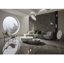 Helles Wohnzimmer mit keramischen Bodenfliesen in Steinoptik, Sofa und rundem Fenster