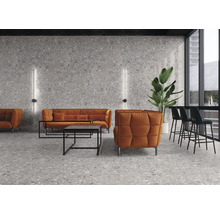 Innenraum mit Terrazzo-Wand, Terrazzoboden, Sofas, Sessel, Tisch, Barhockern und Pflanze.