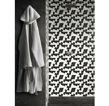 Badezimmer mit geometrischen Fliesen und Bademantel