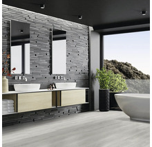 Modernes Badezimmer mit Doppelwaschtisch, Spiegeln, Badewanne und Steinwand