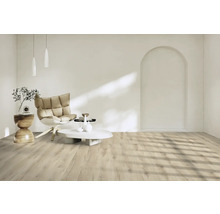 Heller Raum mit Sessel, Tisch und Laminatboden.