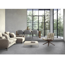 Wohnzimmer mit Sofa, Sessel, Tisch, Stühlen und großem Fenster mit Blick auf Bäume