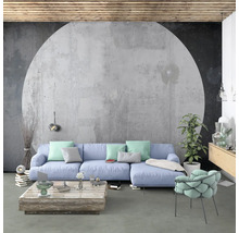 Wohnzimmer mit Sofa, Sessel und Couchtisch vor einer Betonwand