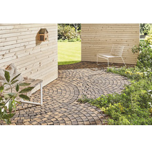 Außenbereich mit Pflastersteinen, Sitzgelegenheit und Holzwand