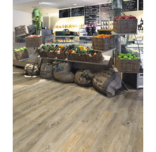 Verkaufsraum mit Holzboden, Körben mit Obst und Gemüse sowie Jutesäcken