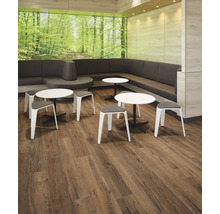 Innenraum mit Sitzgruppe, bestehend aus Eckbank, Tischen und Hockern, und Holzboden