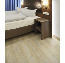 Schlafzimmer mit Bett, Nachttisch und hellem Holzboden