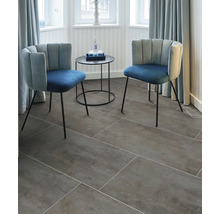 Zwei Stühle und ein Tisch auf einem Bodenbelag mit Fliesenoptik in einem hellen Raum.