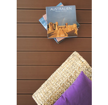 Szene mit Australien-Buch, Korb und Kissen auf einer Holzterrasse