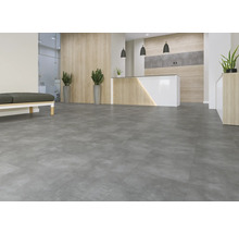 Großzügiger Raum mit grauen Bodenfliesen, Empfangstresen und Sitzbank