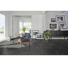 Wohnzimmer mit dunklem Boden, Sessel und Kommode mit Dekoration