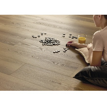 Frau sitzt auf Holzboden mit Buchstaben-Spielsteinen