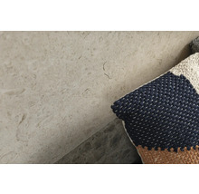 Nahaufnahme einer Fliese mit Natursteinoptik und Kissen