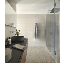 Helles Badezimmer mit Waschbecken, Spiegel, Handtuch und Duschkabine.