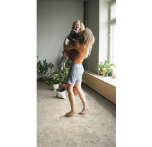 Heller Raum mit Mutter und Kind sowie Pflanzen auf einem Bodenbelag in Steinoptik