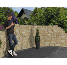 Gestaltungsidee für einen Garten mit Mauersteinen, Bodenplatten und einer Person