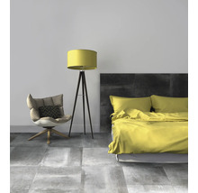 Schlafzimmer mit Bett, Stehlampe und Sessel auf grauem Fliesenboden