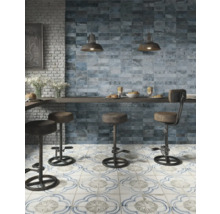 Küchenszene mit blauen Wandfliesen, gemusterten Bodenfliesen und Barhockern.