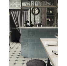 Gastraum mit Fliesenspiegel, Bar, Regalen und Sitzgelegenheiten.