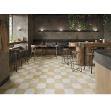 Gastraum mit Schachbrettmuster-Fliesenboden, Tischen und Stühlen.